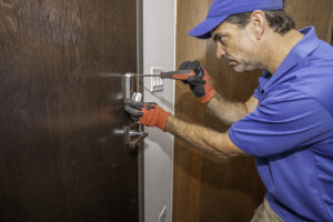 Technician repairing a deadbolt lock on a wooden door with precision